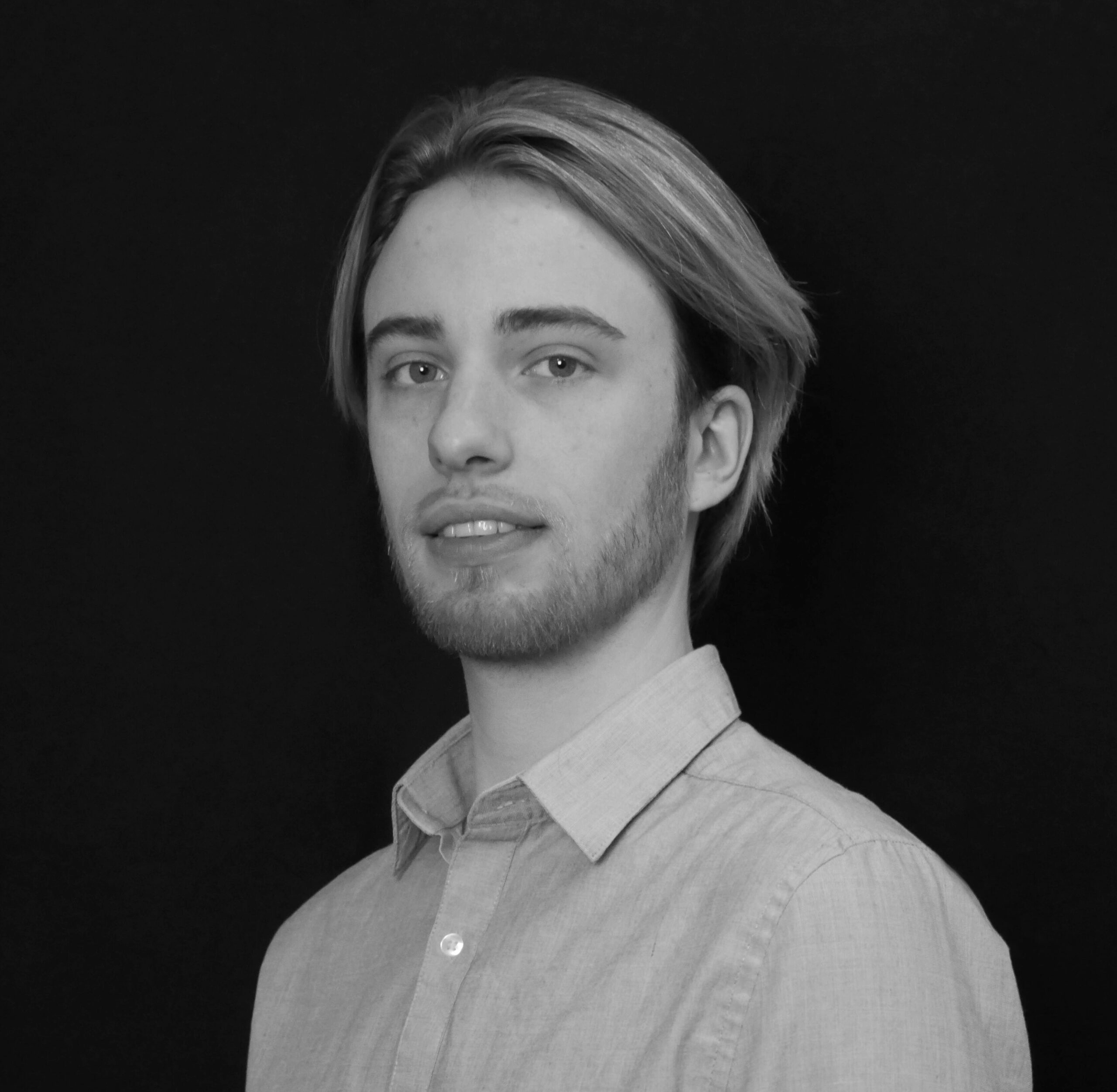 Raphaël, Expert Marketing Ecommerce, est en noir et blanc sur cette image. On voit son portrait jusqu'aux épaules. Il nous regarde en souriant.